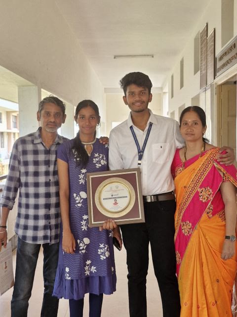 Kanish with his family, holding the ABARAM plaque in a college corridor