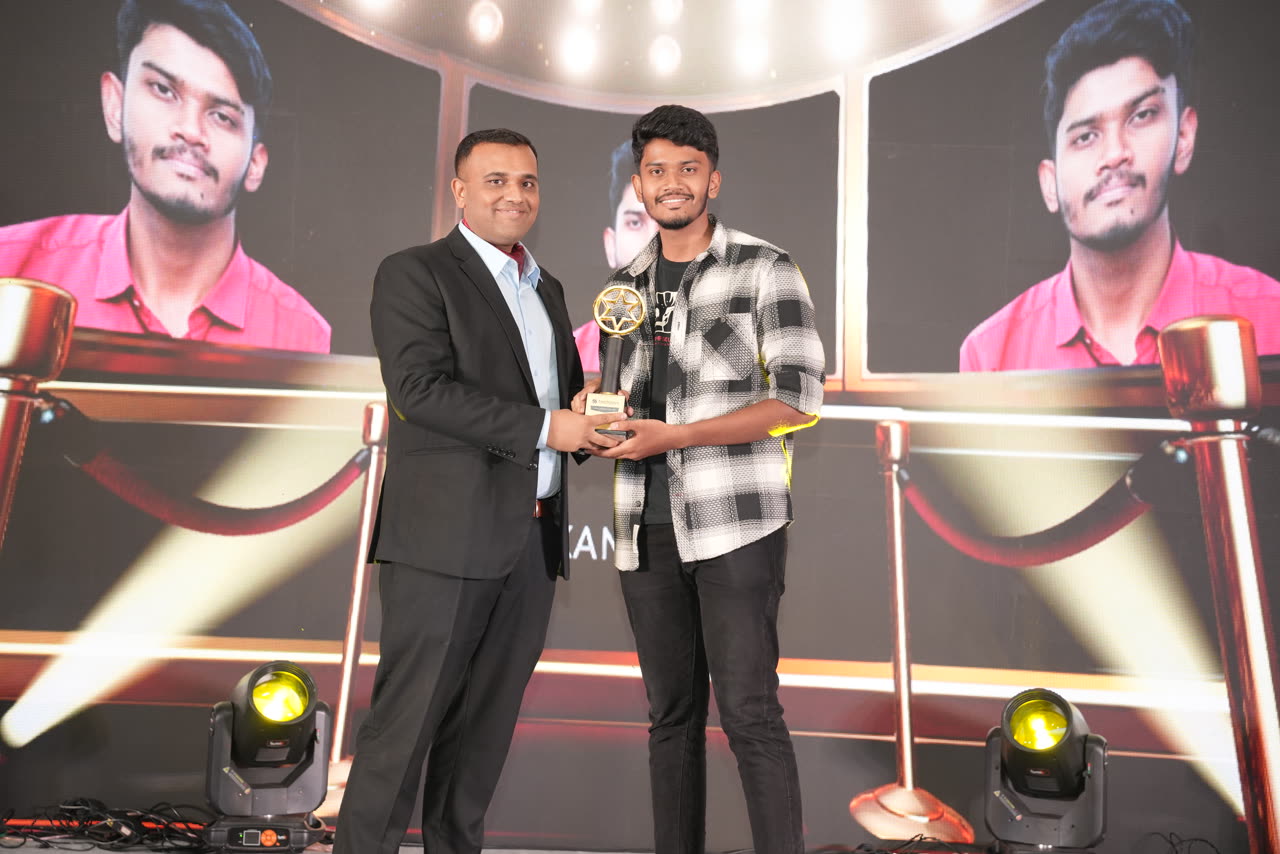 Kanish receiving the Best Fresher trophy from Deena, Chief Business Officer, on stage